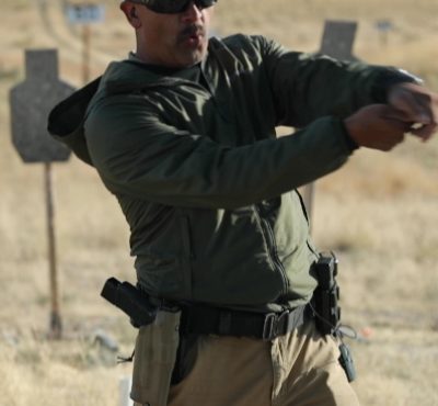 businessman aiming with a gun into the camera
